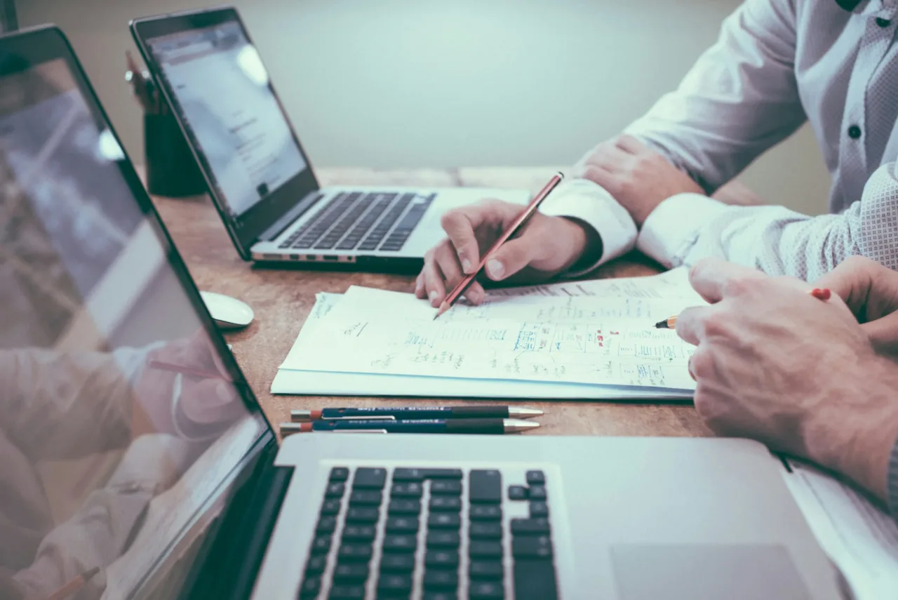 person holding pencil near laptop computer illustrate an on-page SEO optimization